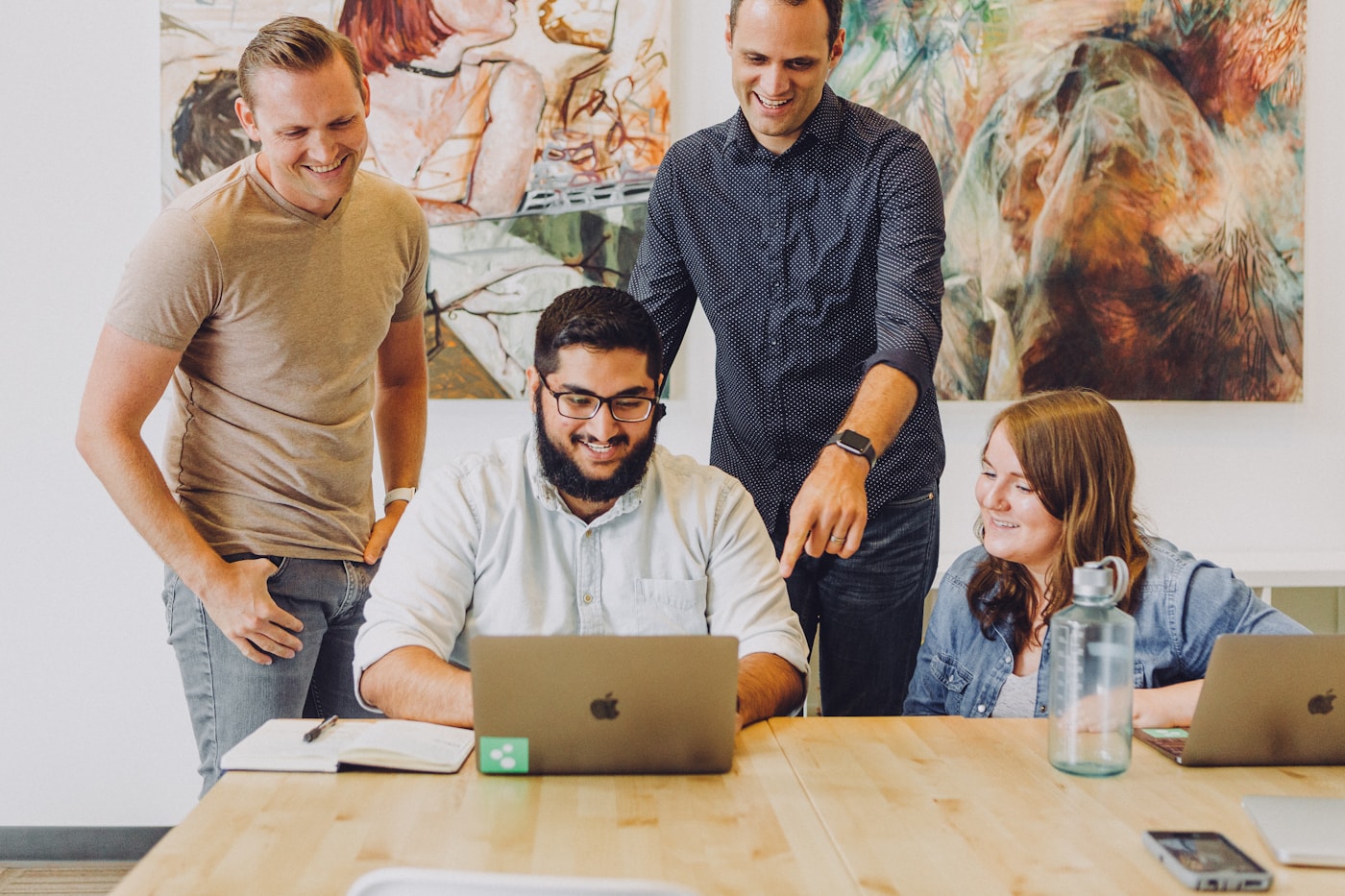 People reviewing work together around a laptop